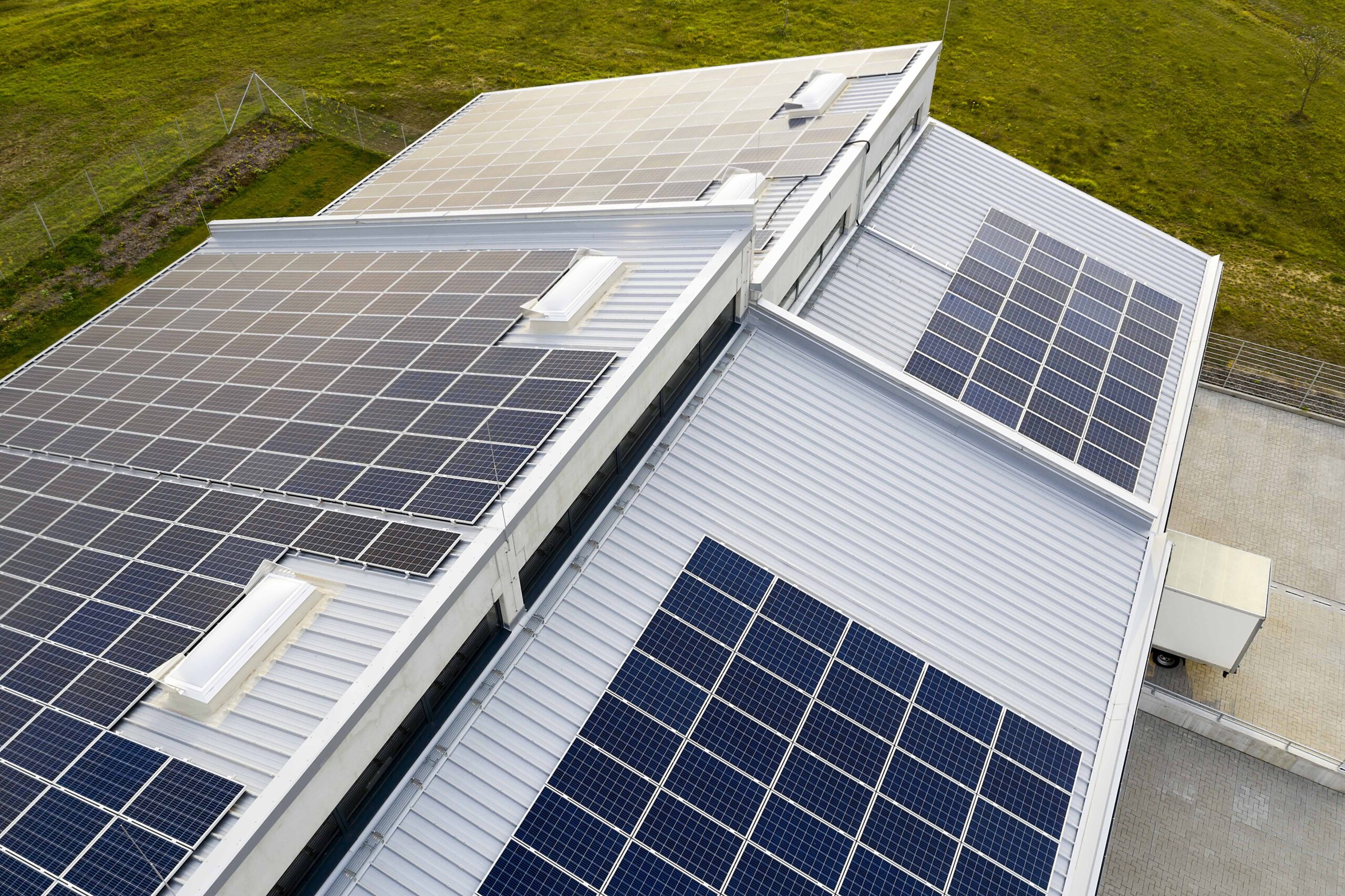 Solaranlage auf Dachfläche einer großen Fabrikhalle von oben