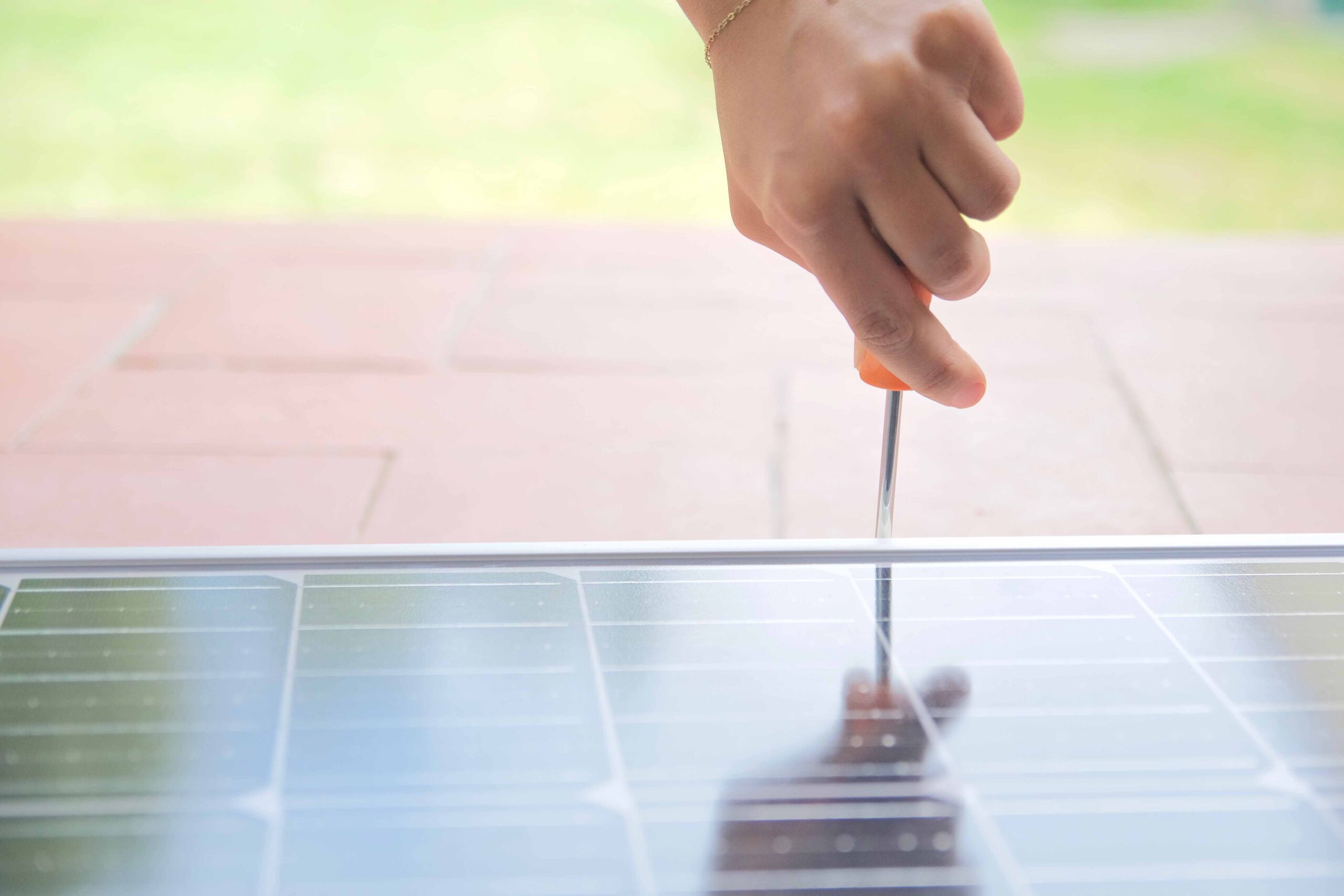 Hand die Schraubenzieher in der Hand hält justiert ein Solarpaneel